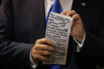 U.S. Republican presidential candidate Donald Trump checks his notes before speaking at one of the New England Council's "Politics and Eggs" breakfasts in Manchester, New Hampshire November 11, 2015.