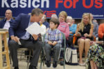 U.S. Republican presidential candidate and Ohio Governor John Kasich talks to six year-old Finn Ladue while being introduced at a campaign town hall meeting in Stratham, New Hampshire October 9, 2015.
