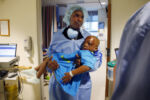 Boston, Massachusetts -- 4/21/2015-- Alex carried Leo into the operating room before his surgery at Shriners. Alex had never been a parent, when the pair first arrived in Boston he wondered how he would care for this wounded, spunky boy in a place where they didn't know anyone.