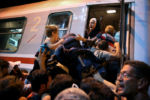 A woman reaches for a child while boarding a train for refugees and migrants who recently crossed the border from Serbia to Tovarnik, Croatia. Migrants said they were eager to move on, although their destination was not always clear. Croatia appeared unprepared for the sudden influx of migrants.