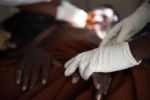 A nurse holds Samwell Mosota Omaiyo's hand during treatment on Saturday afternoon at the Texas Cancer Center in patient facility in Nairobi, Kenya on Saturday, Aug. 22, 2015. Nurses here are trained in palliative care and give round the clock care to over a dozen patients in this small medical building.