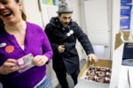 March 1, 2016 - Volunteers Yegyl Tresser (center), of Brooklyn, N.Y., and Tiffany Anning, of Boston, Mass., react at Massachusetts campaign office in Boston, Mass., to donuts brought by a volunteer that have Sen. Bernie Sanders' face painted on them in icing.