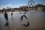 With Palace Playland in the background, Jenny Gouthro, 12, of Salem, N.H., works her back handspring at Old Orchard Beach in Maine. ÒShe could do that all day. She has to get her practice in; she does gymnastics five hours every day,Ó says her mother, Melissa Gouthro. ÒIÕve been coming here since I was probably her age.Ó