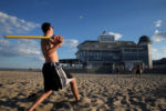 Sean Deely, 16, of Grafton, Mass., plays Wiffle ball with his Òbeach familyÓ at New HampshireÕs Hampton Beach in late July. He and his friends say their families have been meeting for a week at the beach all their lives.