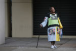 A woman wearing a dress with images of U.S. President Barack Obama on it waits outside after a campaign rally with President Obama and U.S. Democratic presidential candidate Hillary Clinton in Charlotte, North Carolina July 5, 2016.