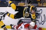 Boston Bruins left wing Brad Marchand, top, goes airborne after slamming Carolina Hurricanes defenseman Brett Pesce.