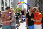 (L-R:) Chris Hemming, kisses Tristan Davison as Jeffery Greamo, of Boston, embraces his partner Jon Paul during a moment of silence held for the victims of a mass shooting at the Pulse night club in Florida.