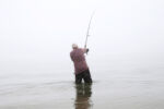 John Gatto, of Revere, casts out into the surf in the fog at Revere Beach as he fishes for stripers in Revere, MA July 5, 2016.