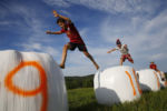 Children leapt across bales of hay as the farmers who were competing in the 2nd Annual Farmer Olympics worked on word problems.