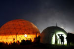 People cast silhouettes against the side of a dome inside the Oceti Sakowin camp.