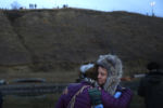 Protesters embrace as police stand on a hill top in Cannon Ball, ND near Standing Rock during an ongoing dispute over the building of the Dakota Access Pipeline.