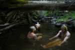 Rainbow family members bathe in a swimming hole.