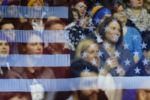 Audience members sit behind the reflection of a U.S. flag as U.S. Democratic presidential candidate and U.S. Senator Bernie Sanders speaks at a campaign rally in a hockey rink at Monroe Community College in Rochester, New York April 12, 2016.