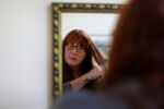 Straus straightens her hair in her bedroom as she begins the day. "I'm blessed with good hair." she said.
