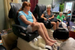 At Mia's Nails, Lindsey Straus (left) gets her toenails painted as she chats with Kathy Santoian and Kathy's mother Nona Merullo(green shirt).