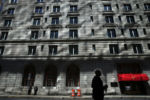 A pedestrian passes down Trinity Place as sunlight reflects onto the Fairmont Copley Plaza in Boston, MA.