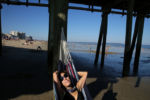 Sandra Pires relaxes under the pier while her son enjoys the water at Old Orchard Beach. It's the last day of their vacation, "we're definitely coming back. Being a single mom... the people are great here, it's family friendly, there's live music and it has a night life too. Can't beat that, it's wonderful."