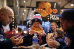 Adam Cox, Karl Ward, and Colt Reid (left to right) enjoy a meal at New York Pizza on Tremont Street. The group had just attended a Red Sox game and were happy about a Boston victory.