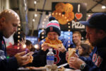 Adam Cox, Karl Ward, and Colt Reid (left to right) enjoy a meal at New York Pizza on Tremont Street. The group had just attended a Red Sox game and were happy about a Boston victory.