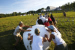 Farmers pushed 700 lb bales of hay around a course during the wrapped bale push event in the 2nd Annual Farmer Olympics at Broad Acres Farm.