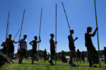 Boys line up as they wait to take warmup jumps in the pole vault event at Sudbury High School for the Division One track meet.