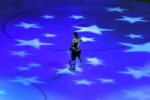 The Boston Bruins vs Vancouver Canucks- Bruins goalie Tuukka Rask stands on the ice covered with light-projected stars during the National Anthem.