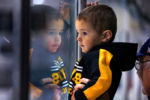 Anthony Silva, 2 from Foxborough is reflected in the glass at Ristuccia Hockey Arena watching Boston Bruins players go through drills during the Bruins Development Camp.