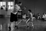 Boxing coach Russell Kimber works with student Rey Hance, as other students wait their turn to box.