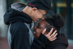 Liniște, left, a 22-year-old gay woman who is experiencing homelessness, embraces her girlfriend Tay in Dudley Square on Oct. 10, 2016 in Boston, MA.