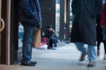 Liniște, a 22-year-old gay woman who is experiencing homelessness, packs her bag on the sidewalk in downtown Boston as she waits for her girlfriend Tay to end her shift at a nearby clothing store.