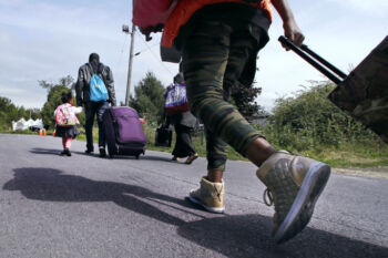 Wearing her gold high-stop sneakers, Lena Gunja, 10, originally from Congo and who had been living in Portland, Maine, follows her family as they approach an unofficial border crossing with Quebec while walking down Roxham Road in Champlain, N.Y., Monday, Aug. 7, 2017. "In Trump's country they want to put us back to our country," said Gunja. "So we don't want that to happen to us so. We want a good life for us. My mother, she wants a good life for us."