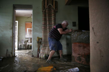 Toa Baja, Puerto Rico -- 9/30/2017 - In Toa Baja, on the island’s northern coast, bulldozers worked to clear mud from the streets as families were digging out, trying to salvage the few belongings that were left. Geraldo Rivera, 51, had come to help his neighbor move heavy furniture ruined in the flood waters out of his home.