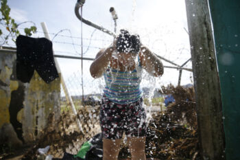 Arecibo, Puerto Rico -- 10/01/2017 - With aid and supplies slow to come to this corner to the island scores of residents in Arecibo like Deborah Estremera came to bathe and wash their clothes in one of the few available spigots of fresh water here. They knew it was unsafe to drink but still filled jugs so that they could flush toilets and clean their homes.