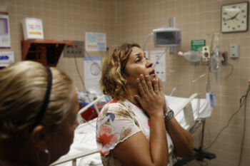 Caguas, Puerto Rico -- 9/29/2017 - Myriam Ruiz waits inside the emergency room where her father, Luis Alberto Ruiz, is being treated after he tied a belt around his neck and tried to hang himself. When Myriam found him behind their home, she began to scream. Moments later, two neighbors rushed over and helped pull his limp body down from the roof. There was no way to call an ambulance, so they carried him to their Jeep and sped to the hospital.