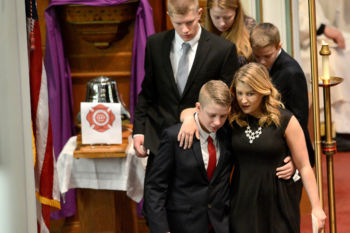Alyssa Toscano, bottom right, and her siblings Patrick, William, Michael and Mary Cate leave the lectern after giving a eulogy for their father, fallen Watertown firefighter Joe Toscano, during a funeral service St. Patrick's Church in Watertown Wednesday, March 22. Toscano, 54, died after he collapsed while battling a two-alarm fire on Merrifield Avenue. He had been a Watertown firefighter for two decades.