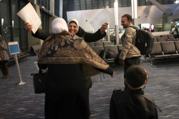The Last Refugee: Through the Closing Door.
A year ago, eight Syrian families fled the violence of their homeland and immigrated to Greater Boston. They were among the last such refugees allowed into the United States as a result of the Trump administrationÕs multiple efforts to ban immigrants from certain majority Muslim countries, including Syria. To smooth the transition, Jewish Family Service of Metrowest launched the Syrian Refugee Humanitarian Project, working with Jewish synagogues, Islamic centers, doctors, dentists, businesses, and an army of volunteers to provide safety, hope and a new life to these immigrants. Out of the twelve families scheduled to arrive, only eight made it to America before the travel ban and Trump administration's lowering of refugee numbers halted the process. The families shared their sometimes painful, sometimes joyous journey including their struggles to acclimate to the climate, both meteorological and political; their efforts to adapt to a new culture while preserving their heritage; their determination to achieve self-sufficiency; and the bonds of friendship they forged with people who practice a religion they were taught as children to hate.
*******************************************
1. At Logan Airport, Nermin Helaly, a lead case manager with JFS Syrian Humanitarian Project, greeted Um Alnoor with a giant hug. They were the first of eight Syrian refugee families to arrive before the Trump Administration enacted a ban on immigrants from certain Muslim majority countries, including Syria. (EditorÕs note: Some of names have been changed to protect the subjectÕs privacy.)