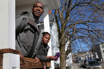 Sendegeya, left, and his daughter Maria, 17, looked for the school bus while waiting for his other children to arrive at their home in Lowell.