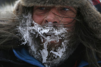 Fort Kent, ME -- 3/4/2017 - Maxime Leclerc-Gingras' beard is covered in ice as he crosses the finish line of the 30 mile Can-Am Crown Race. There are three different races: 30 miles, 100 miles and 250 miles. This year the 250 mile race had to be cut down to 209 miles because of an early thaw that melted rivers and made some of the usual trails impassable.