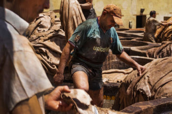 Workers trim hides after pulling them out of dying wells at the Chouara tannery in the Medina in Fes, Morocco on July 29, 2017.