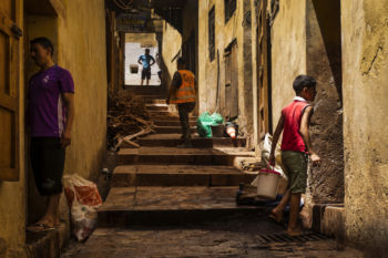 Workers and visitors stand in the entrance way to the Chouara tannery in the Medina in Fes, Morocco on July 29, 2017.