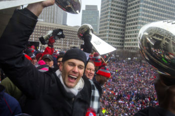 Tom Brady and Bill Belichick hoist the Lombardi Championship Trophies in front of the thousands of fans at Boston City Hall.