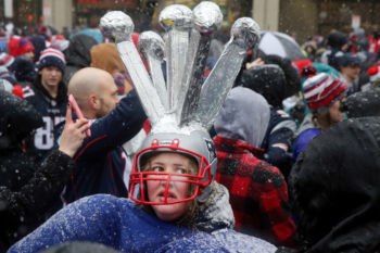 Patriots fan Annie Cushing celebrates wearing a hat of five Super Bowl trophies during the New England Patriots Super Bowl LI victory parade.
