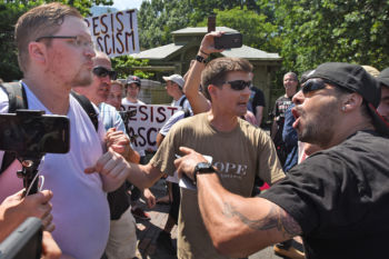 An attendee at the Boston Free Speech Rally (L) gets yelled at while walking through a crowd at the end of the rally