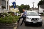 Democratic presidential candidate and former governor of Colorado John Hickenlooper plays a newly-purchased banjo following a campaign event at the home of former New Hampshire state representative Philip Spagnuolo in Laconia, N.H., on July 17, 2019.