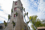 All 12 Brockton firefighter recruits use leg-locks to secure themselves on pole ladders before releasing their arms and leaning back in unison during pole-ladder training on Tuesday, May 7, 2019 at station no. 6 on West Street.