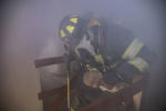 A recruit carries a mannequin babydoll out of a simulated house fire on Thursday, May 2, 2019 in Brockton.