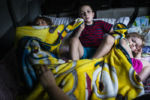 BIDDEFORD, ME - 07/13/2019 Siblings from left Evan, Dylan and Laya watch a movie while getting ready for bed in the back of their family's van. Camping presents special problems for the Lupien children. Dylan needs to be in an enclosed space so that he can not run away; a tent is too flimsy. So Patrick and Mariah tuck the children into the back of their Toyota Sienna minivan each night, in a nest of blankets and pillows, cracking the windows and zip-tying the doors shut from the outside to keep them safe. ÒThe questions...am I poor enough to get help?" asks Mariah. "Will they think I'm lying anyway? Homeless with kids should matter, right?Ó