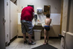 BIDDEFORD, ME - 07/25/2019 Patrick Lupien, left, brushes his teeth with his son Evan while they get ready for the day in the campground bathroom in the early hours of the morning. Campground life requires a very rigid schedule for the Lupien family. They wake up at 5:30, have cereal for breakfast, drive to the bathroom, and take the children in shifts to wash up and get ready for the day. Patrick throws on his work clothes and they rush to the campground entrance to await the bus before Patrick heads off to work. ÒBeing this poor... this level of poverty means to live in constant fear," says Mariah. "WeÕve been told weÕre doing everything right. WeÕve taken every piece of advice and acted on it. DoesnÕt seem to matter.Ó