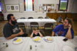 EXETER, NH - 08/23/2019 After arriving to the New Hampshire homeless shelter with an uncertain future, Patrick Lupien talks with Mariah while Laya eats dinner at the church. Each week, the family shuttles to a new church with some belongings. Patrick began applying for a job; the program gave him a gas card and a suit for job interviews. Still, it was difficult to live within the strict rules and requirements of the program, Mariah said. They had been struggling on their own, but at least they had been in charge. ÒWith homelessness, there's an incredible amount of loss to deal with," says Mariah" It reaches far beyond a home and comforts of safety. There's a loss of dignity, loss of confidence, loss of security.Ó