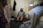 EXETER, ME - 11/24/2019 Exhausted, Patrick Lupien leans against the bedroom door while his daughter Laya, left, and son Evan jump back and forth on the bed. Often sharing one large room while at the shelter, the family of five is in much need of their own space. Two weeks after the family moved south into NH, the horizon did become brighter. Patrick got a job as a field engineer at Granite State Communications. His salary was $80,000, double what he was making in Maine. He and Mariah celebrated with a high five. Now that Patrick had a well-paying job, they turned to the next hurdle: finding an affordable apartment that could comfortably fit their family.